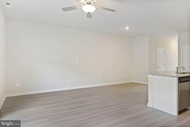 interior space with stainless steel dishwasher, light stone counters, ceiling fan, sink, and light hardwood / wood-style flooring