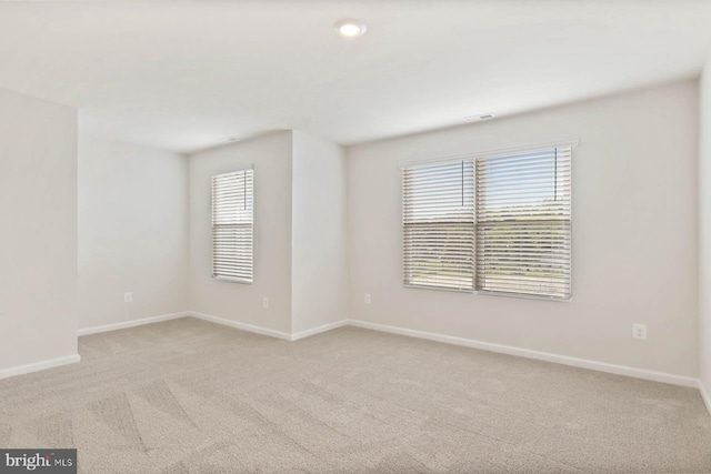 spare room featuring light colored carpet and a healthy amount of sunlight