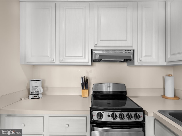 kitchen with ventilation hood, black range, white cabinetry, and sink