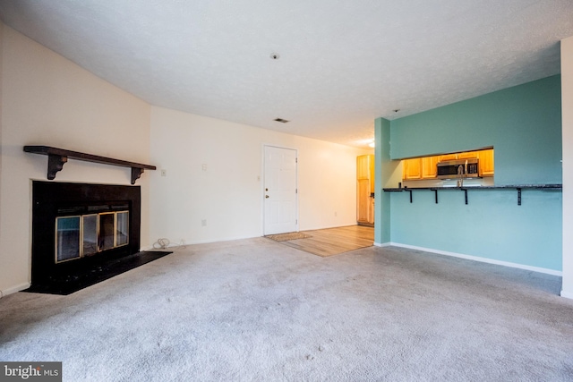 unfurnished living room with a textured ceiling and light colored carpet