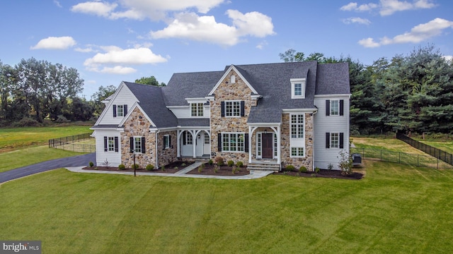 view of front of house with central AC unit and a front yard