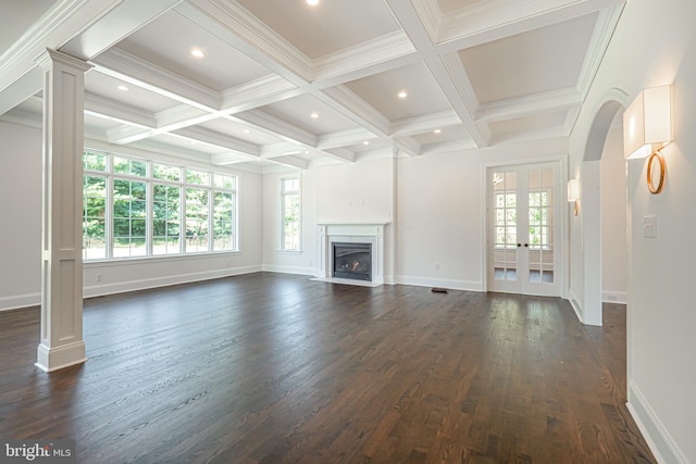 unfurnished living room with dark wood-type flooring, french doors, coffered ceiling, ornate columns, and beam ceiling