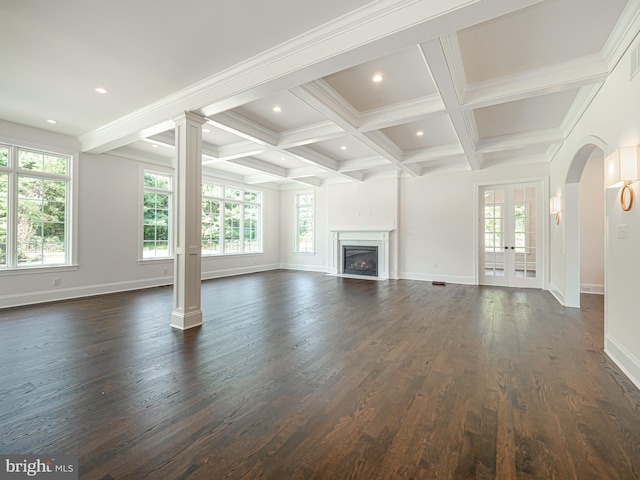 unfurnished living room featuring plenty of natural light, beam ceiling, dark hardwood / wood-style floors, and coffered ceiling