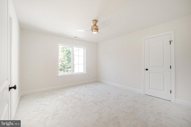 carpeted spare room featuring ceiling fan