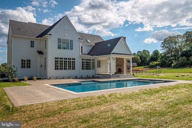 back of house featuring a fenced in pool, a yard, and a patio