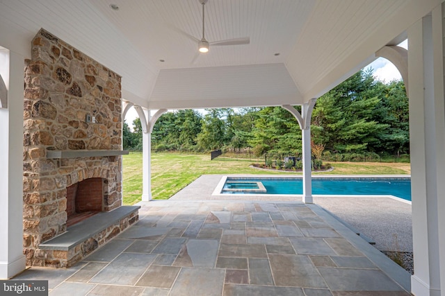 view of swimming pool with an outdoor stone fireplace, ceiling fan, a gazebo, a patio area, and a yard