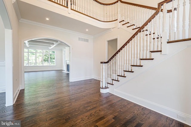 foyer entrance with beam ceiling, dark wood-type flooring, coffered ceiling, and ornamental molding