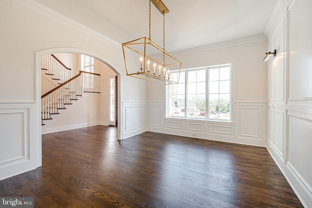 unfurnished dining area featuring a notable chandelier, dark hardwood / wood-style floors, and ornamental molding