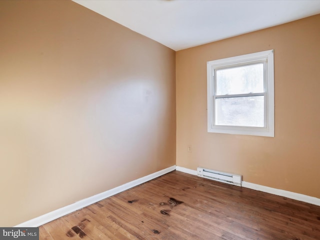 spare room featuring hardwood / wood-style flooring and baseboard heating