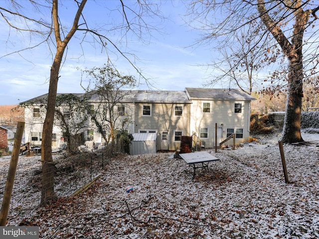 view of snow covered rear of property