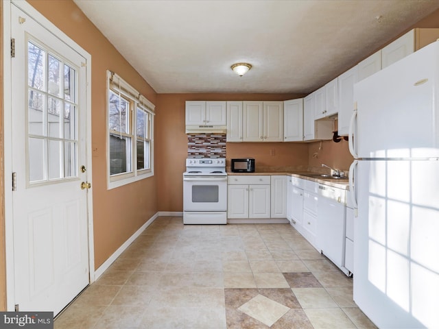 kitchen featuring sink, white cabinets, and white appliances