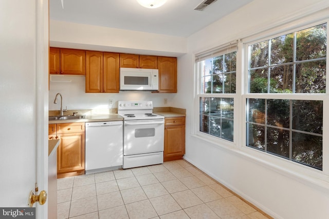 kitchen featuring sink, white appliances, and light tile patterned floors