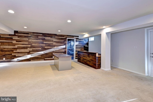 recreation room with light carpet and wooden walls