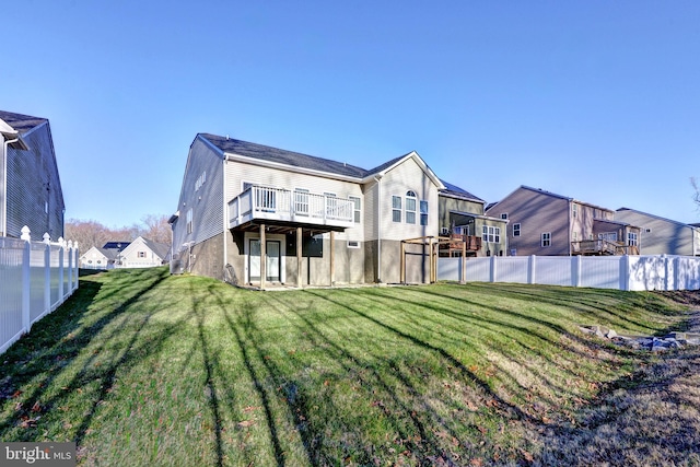 rear view of house featuring a lawn and a wooden deck