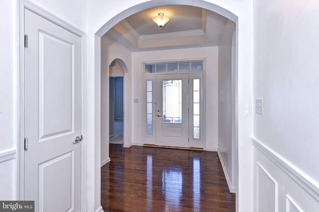 foyer with a tray ceiling, dark hardwood / wood-style floors, and ornamental molding