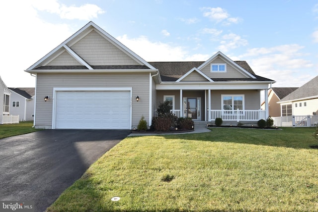 view of front of house with a front yard, a porch, and a garage