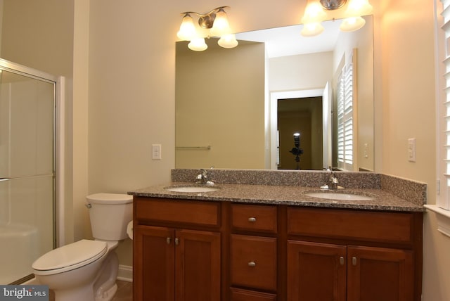 bathroom featuring vanity, toilet, and an enclosed shower