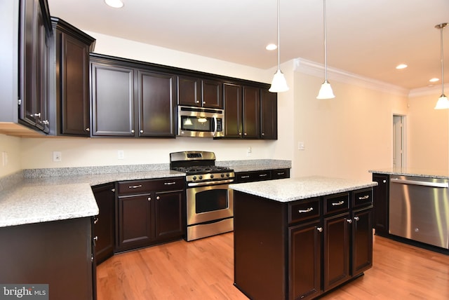 kitchen with appliances with stainless steel finishes, dark brown cabinets, crown molding, decorative light fixtures, and a center island