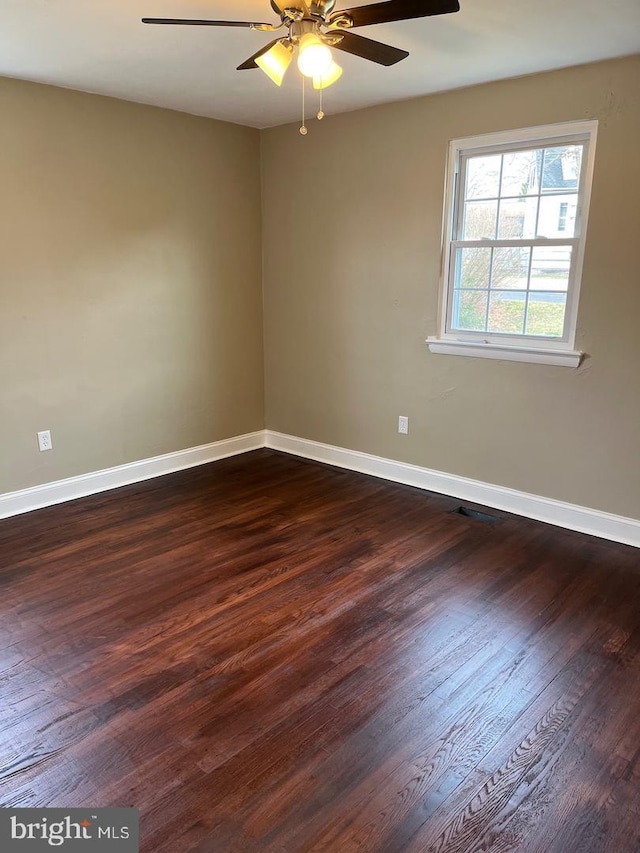 unfurnished room with ceiling fan and dark wood-type flooring