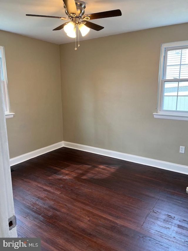 empty room with ceiling fan and dark hardwood / wood-style flooring