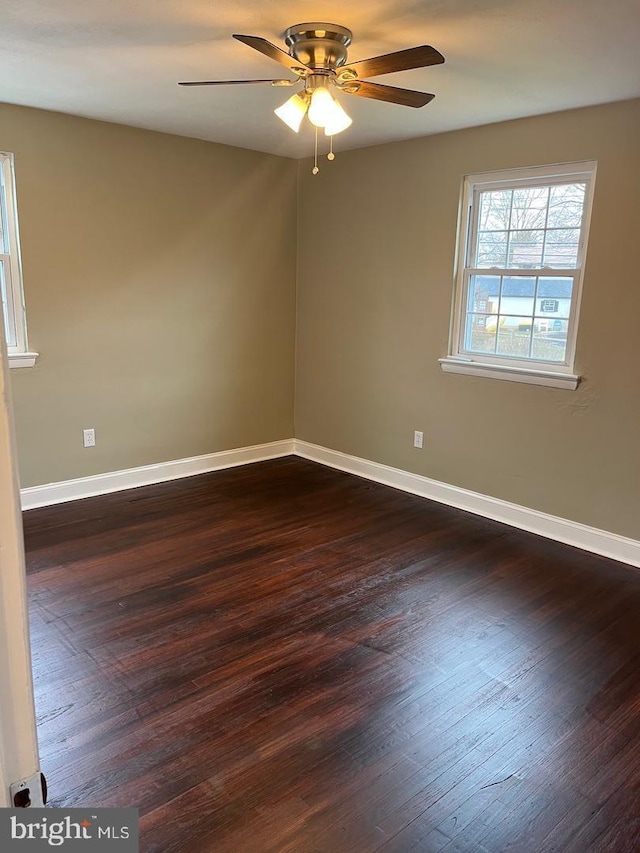 empty room with ceiling fan and dark wood-type flooring