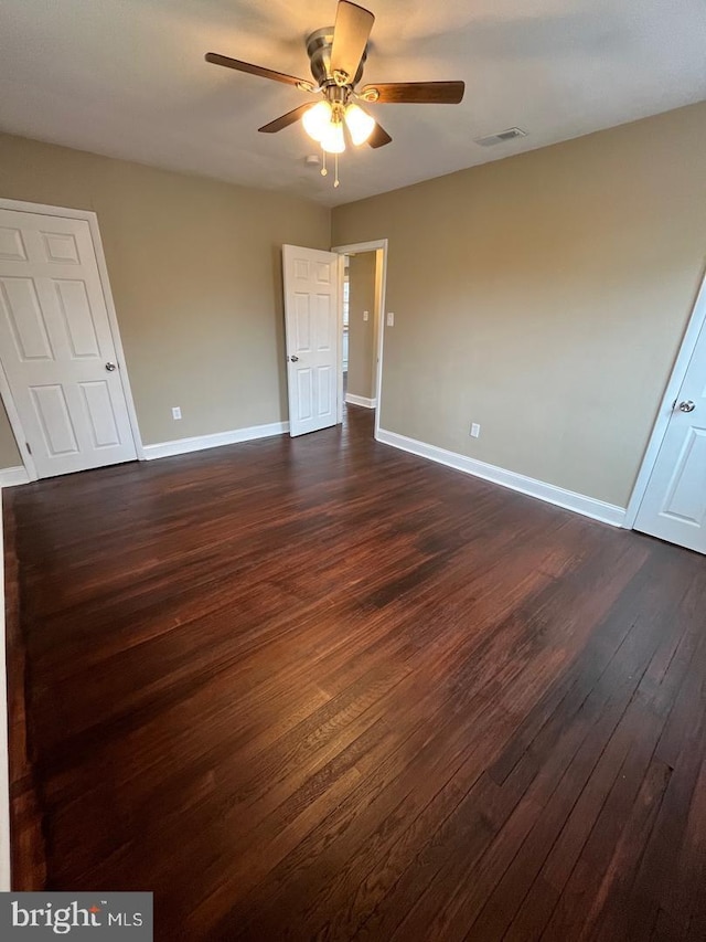 unfurnished bedroom featuring ceiling fan and dark hardwood / wood-style flooring