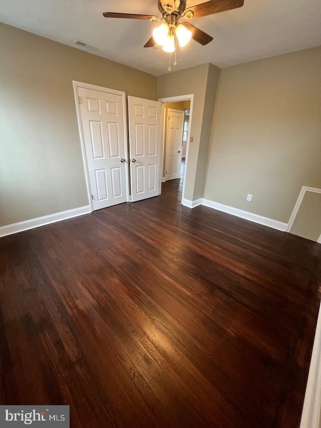 unfurnished bedroom with ceiling fan and dark hardwood / wood-style floors