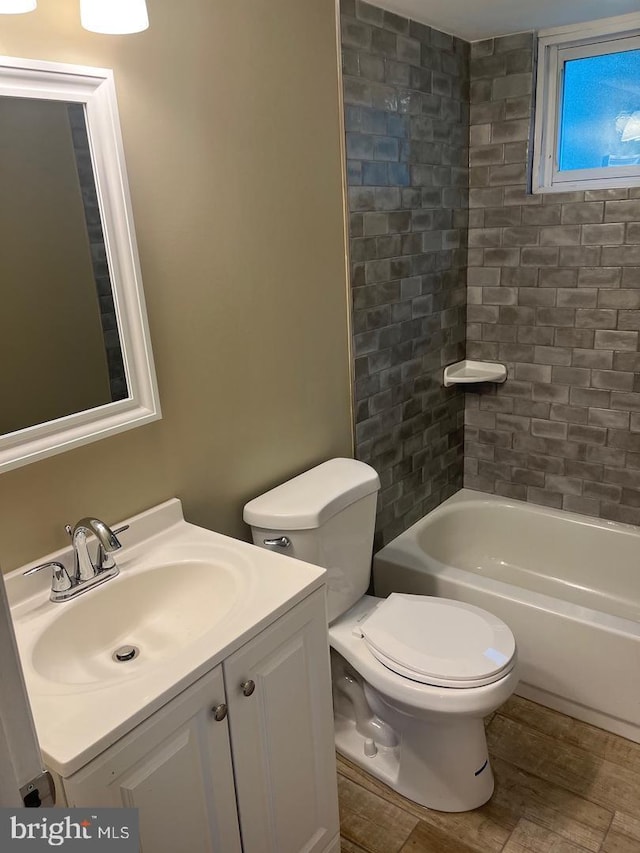 full bathroom with tiled shower / bath, vanity, and toilet