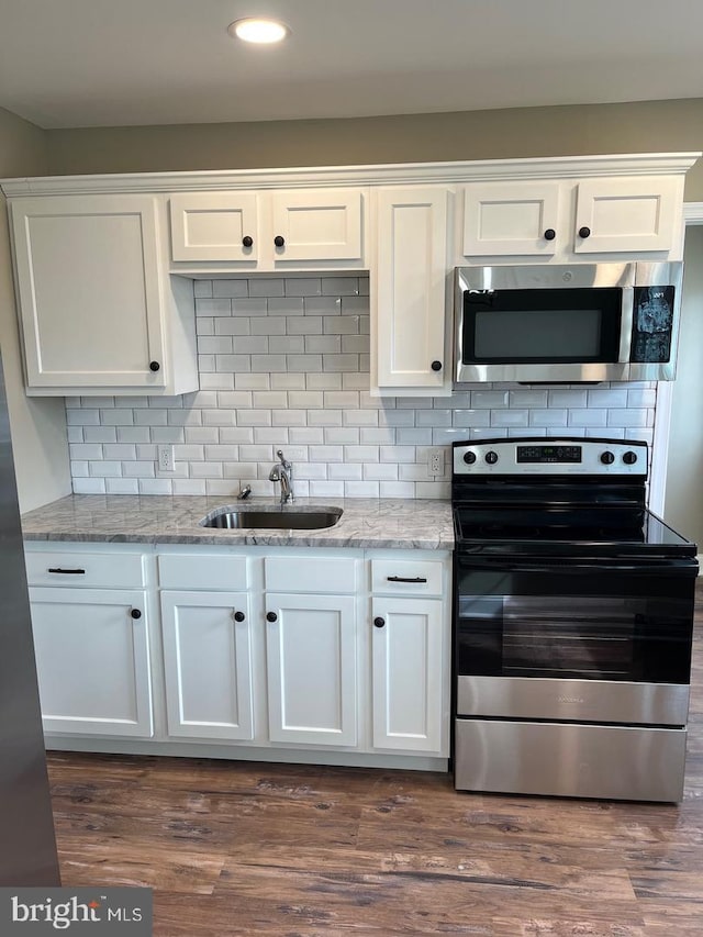 kitchen featuring backsplash, stainless steel appliances, white cabinetry, and sink