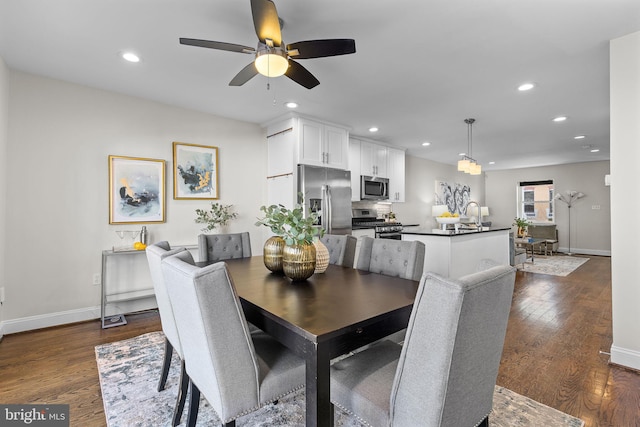 dining space with sink, ceiling fan, and dark hardwood / wood-style floors