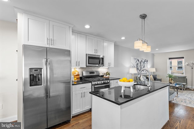 kitchen with sink, white cabinets, pendant lighting, and stainless steel appliances