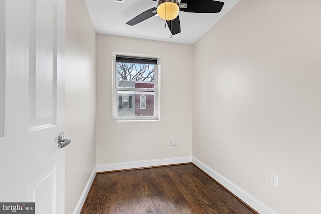 spare room featuring dark wood-type flooring and ceiling fan