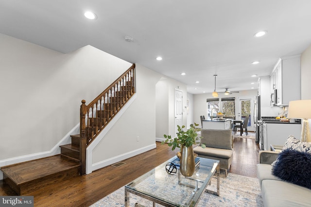 living room featuring dark hardwood / wood-style floors and ceiling fan