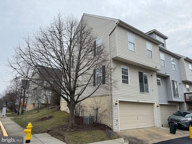 view of property exterior with a garage and central air condition unit