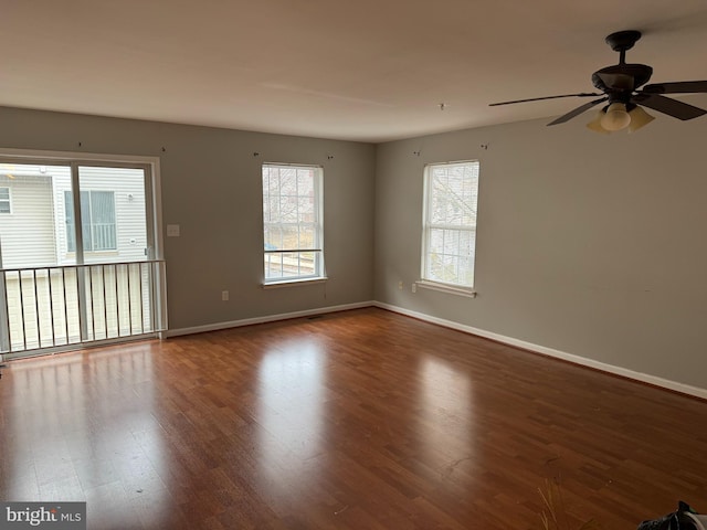 spare room featuring hardwood / wood-style floors, ceiling fan, and a healthy amount of sunlight