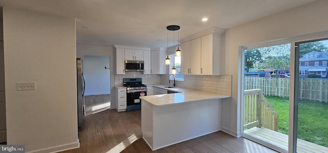 434 Redfern, Hamilton, NJ 08610 - kitchen featuring appliances with stainless steel finishes, dark wood-style floors, decorative backsplash, a peninsula, and white cabinetry