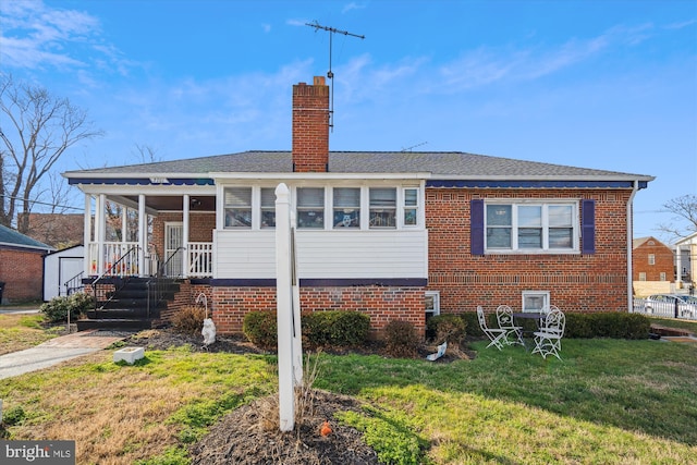 back of house featuring a yard and a sunroom