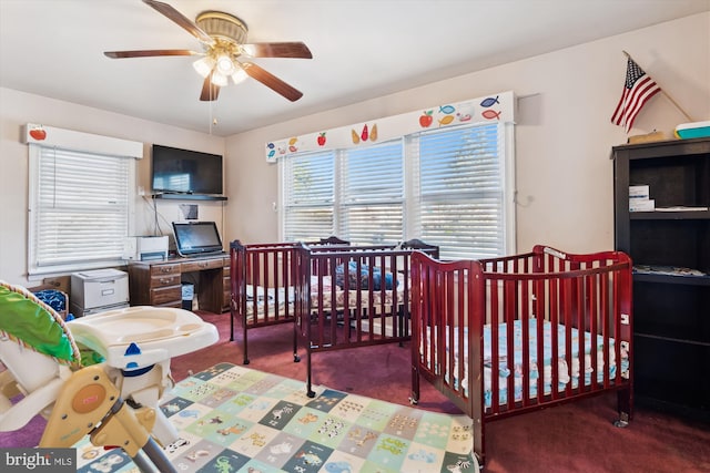 bedroom with dark colored carpet, a nursery area, and ceiling fan