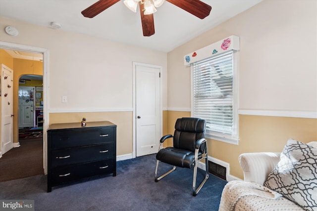 sitting room with dark colored carpet and ceiling fan