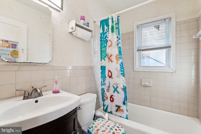 full bathroom with tile walls, vanity, shower / tub combo, and toilet