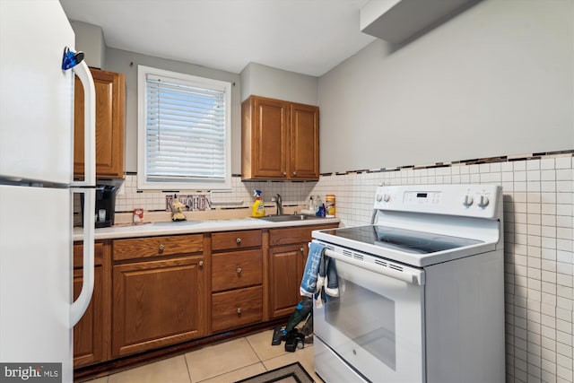 kitchen featuring sink, white refrigerator, light tile patterned flooring, and electric stove