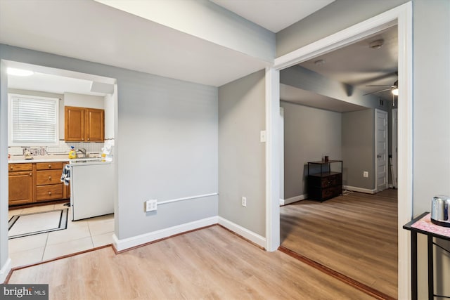 kitchen with decorative backsplash, stove, light hardwood / wood-style floors, and ceiling fan