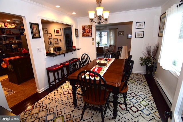 dining space with ornamental molding, a baseboard radiator, an inviting chandelier, and dark wood-type flooring