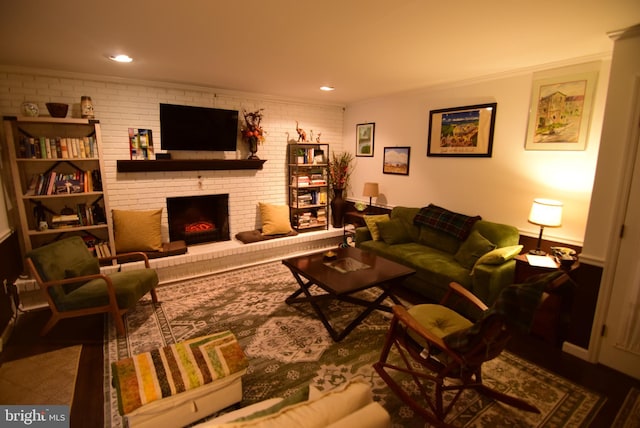 living room featuring ornamental molding, brick wall, and a brick fireplace