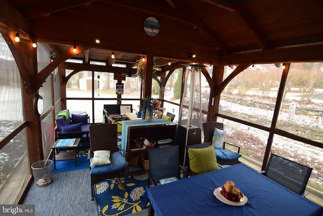 sunroom featuring wooden ceiling, a healthy amount of sunlight, and lofted ceiling