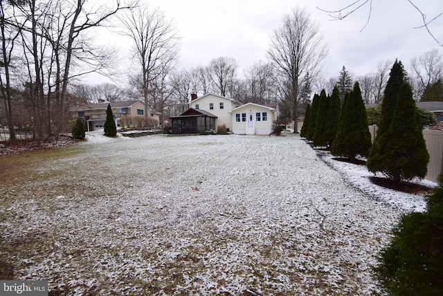 yard layered in snow with a sunroom