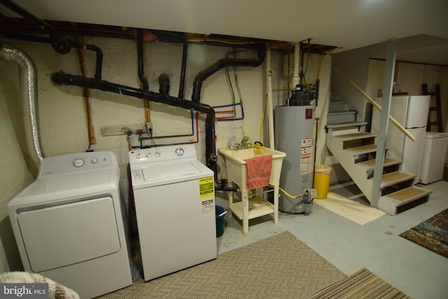 washroom with independent washer and dryer, gas water heater, and sink