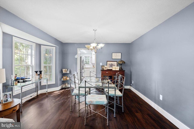 dining space featuring dark hardwood / wood-style flooring and a chandelier