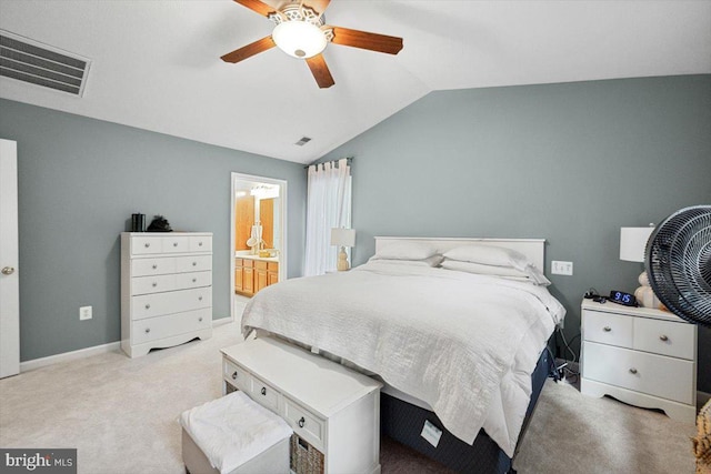 carpeted bedroom with ensuite bath, ceiling fan, and vaulted ceiling