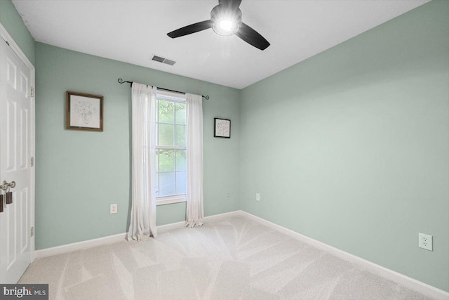 empty room with ceiling fan and light carpet